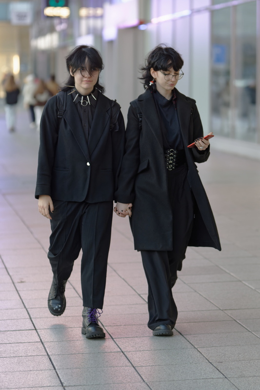18 - Two girls wearing coordinated black outfits and holding hands